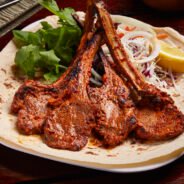 Grilled Lamb Chops with lemon, salad and bread served in dish isolated on table side view of middle east food