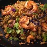 Grilled shrimp salad on a black plate and black background