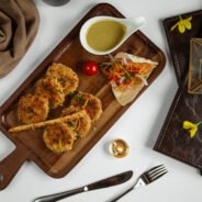 potato balls with vegetables and sauce on wooden board